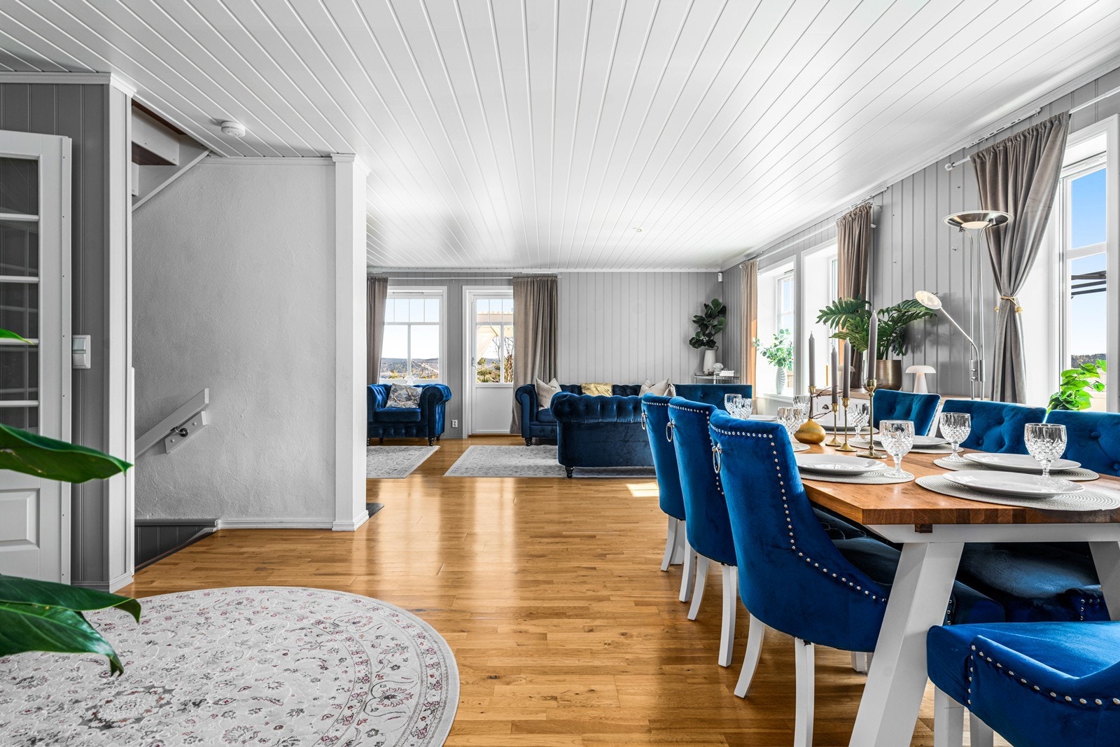 Stuen og spisestuen utgjør et stort, sammenhengende rom med gjennomgående parkettgulv og panel i himlingen. Galleribilde