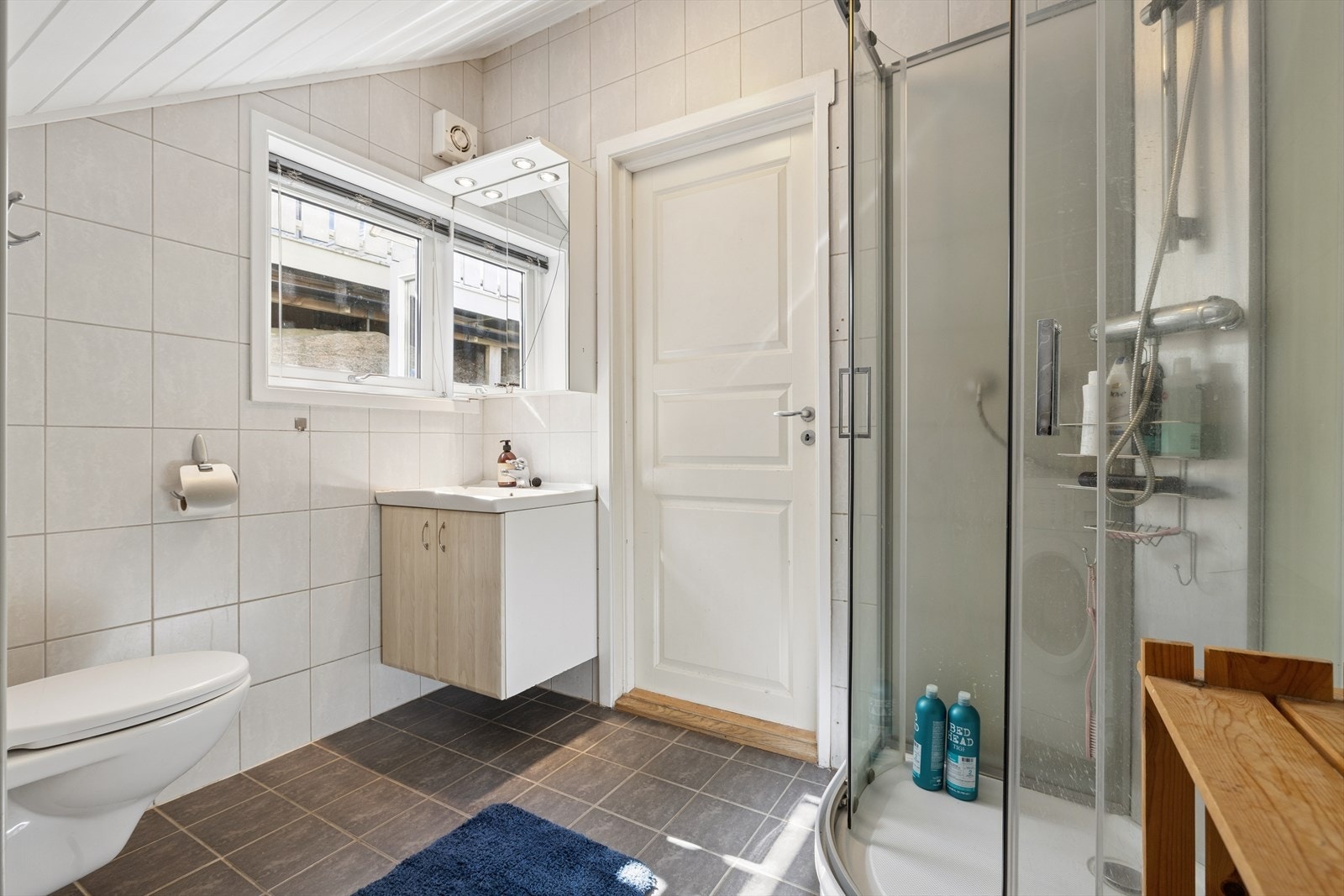 Badet i leiligheten har flislagt gulv med varmekabler og et dusjkabinett av nyere dato. Galleribilde