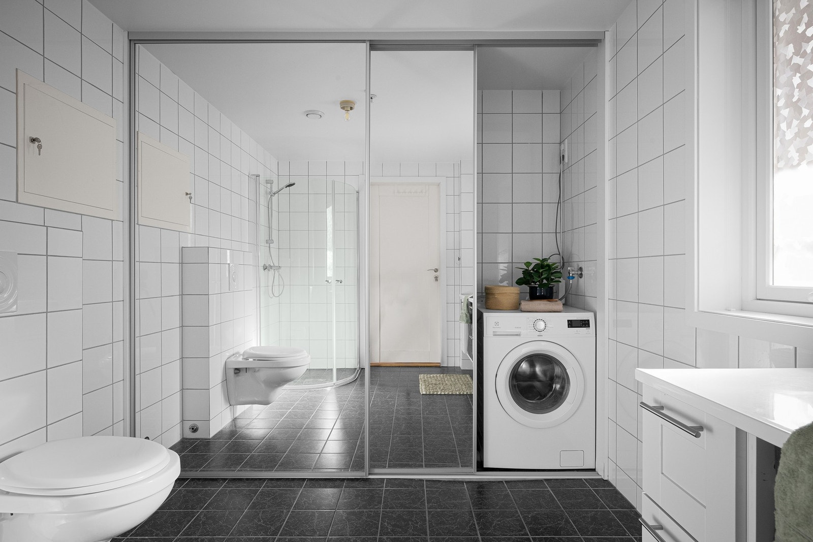 Pent flislagt baderom med gulvvarme og smart skyvedørsløsning Galleribilde