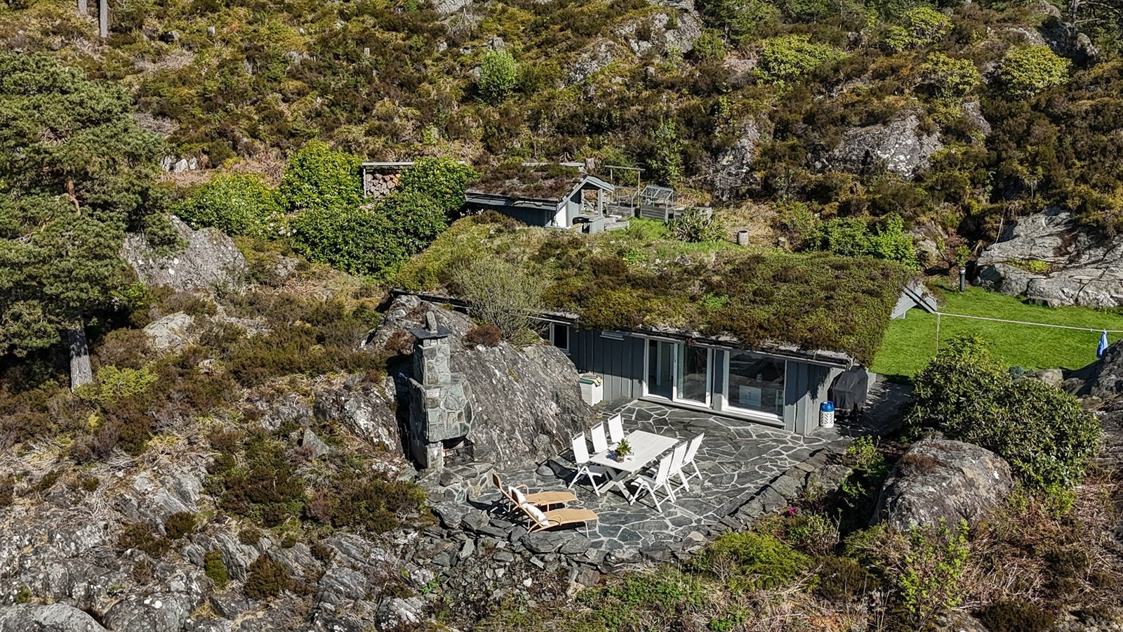 Uteplass i front av annekset. God plass til både solsenger, spisegruppe og her har man også ute-peis må vite. Galleribilde