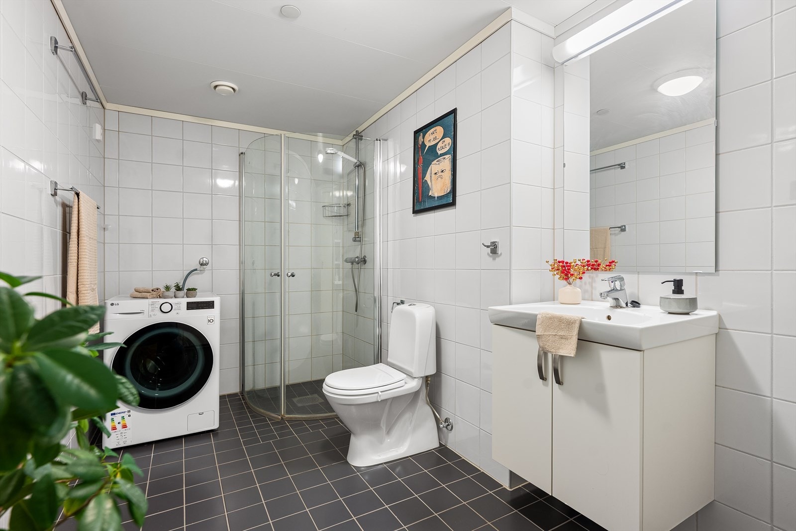 Badet er romslig og innredet med toalett, servant i benkeskap , speil og dusj med svingbare glassdører. Her er det også opplegg for vaskemaskin. Galleribilde