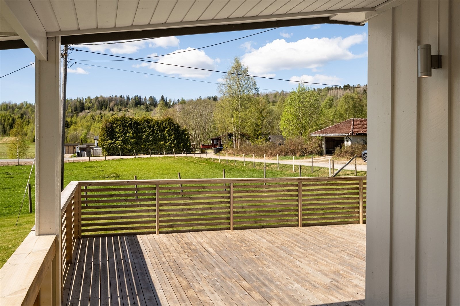 Nyt utsikten mot skog og mark, landlig ro og solen. Galleribilde