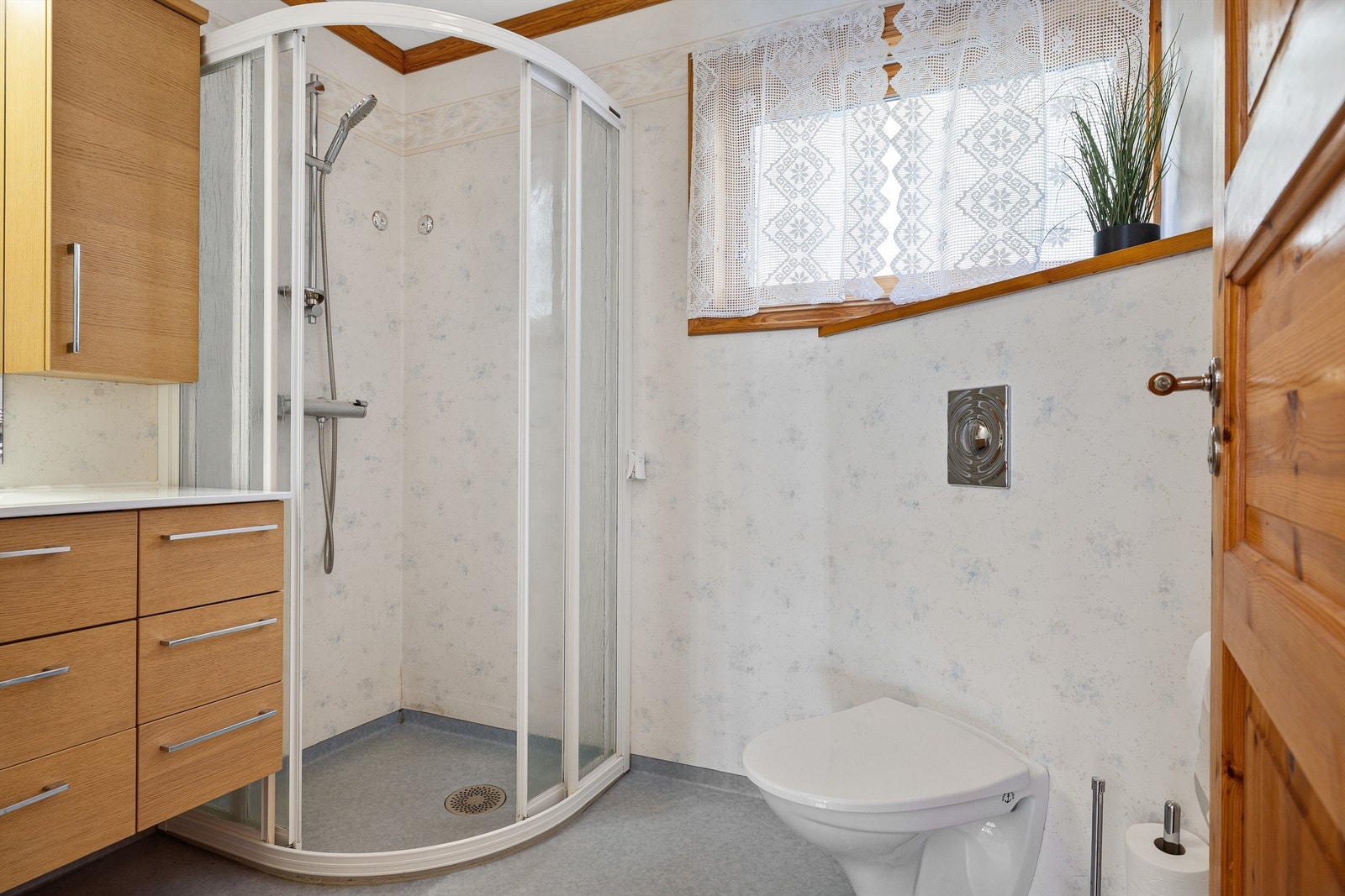 Badet i boligen hovedetasje er innredet med dusjhjørne, veggmontert toalett og baderomsinnredning. Galleribilde