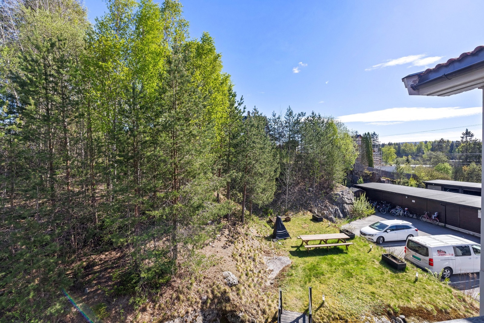 Fra balkongen har du et hyggelig utsyn over grønne nærområder, som gir en rolig og skjermet følelse rundt uteplassen. Galleribilde