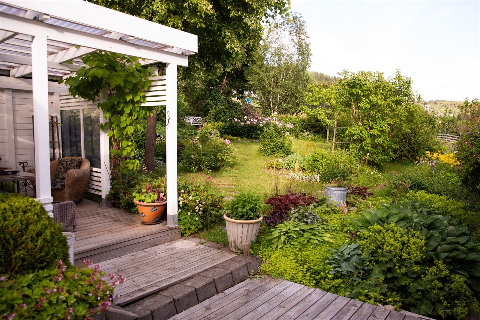 Den store eiertomten er frodig og pent opparbeidet med plen og variert beplantning. Galleribilde