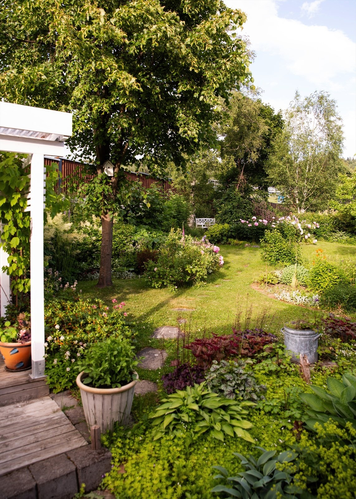 Fra uteplassen har man god oversikt over den parkmessige hagen. Galleribilde