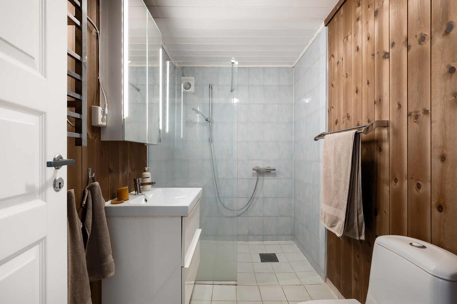 Badet i kjelleren har flislagt gulv med gulvvarme og fliser i dusjsonen. Galleribilde