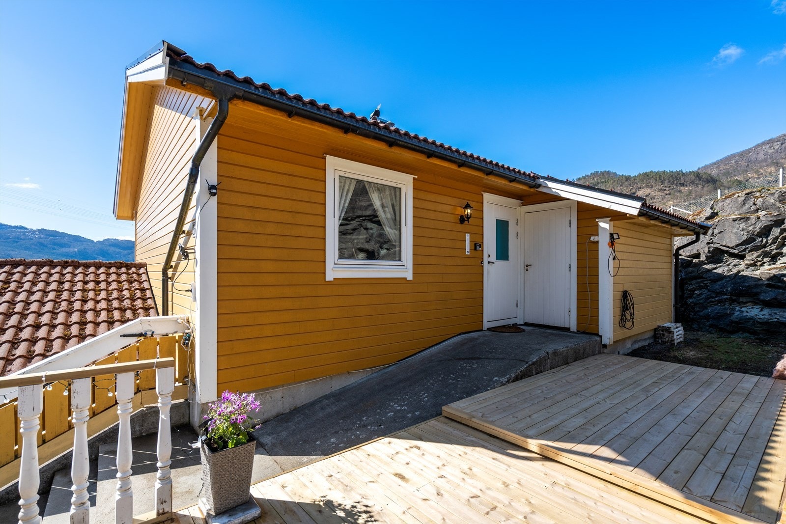 På baksiden av boligen er det en usjenert uteplass med terrassebord og egen inngang. Galleribilde