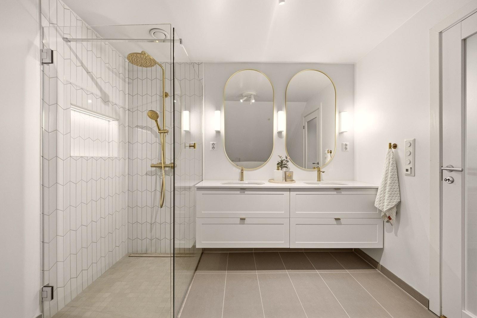 Badet inneholder vegghengt dobbel servantinnredning, regnfallsdusj og toalett Galleribilde
