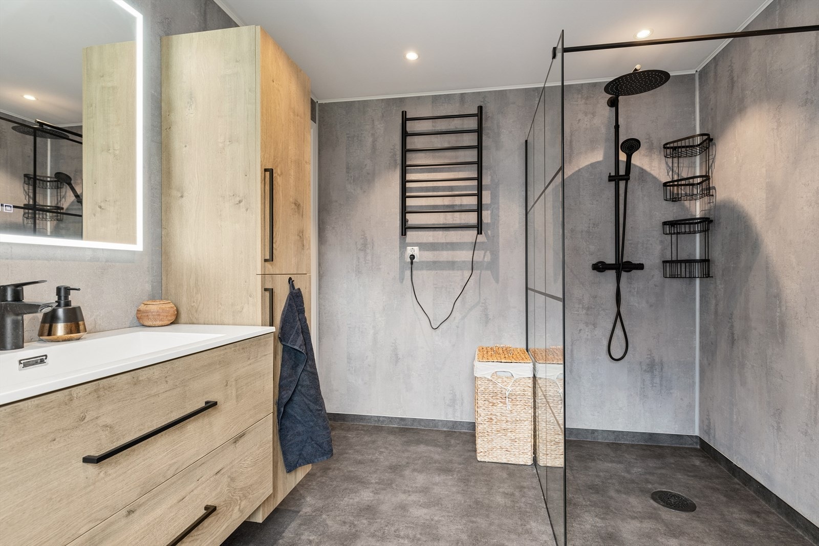 Badet byr på en stor og lettstelt dusj og detaljer sånn som en håndklevarmer gjør hverdagen mer komfortabel. Galleribilde