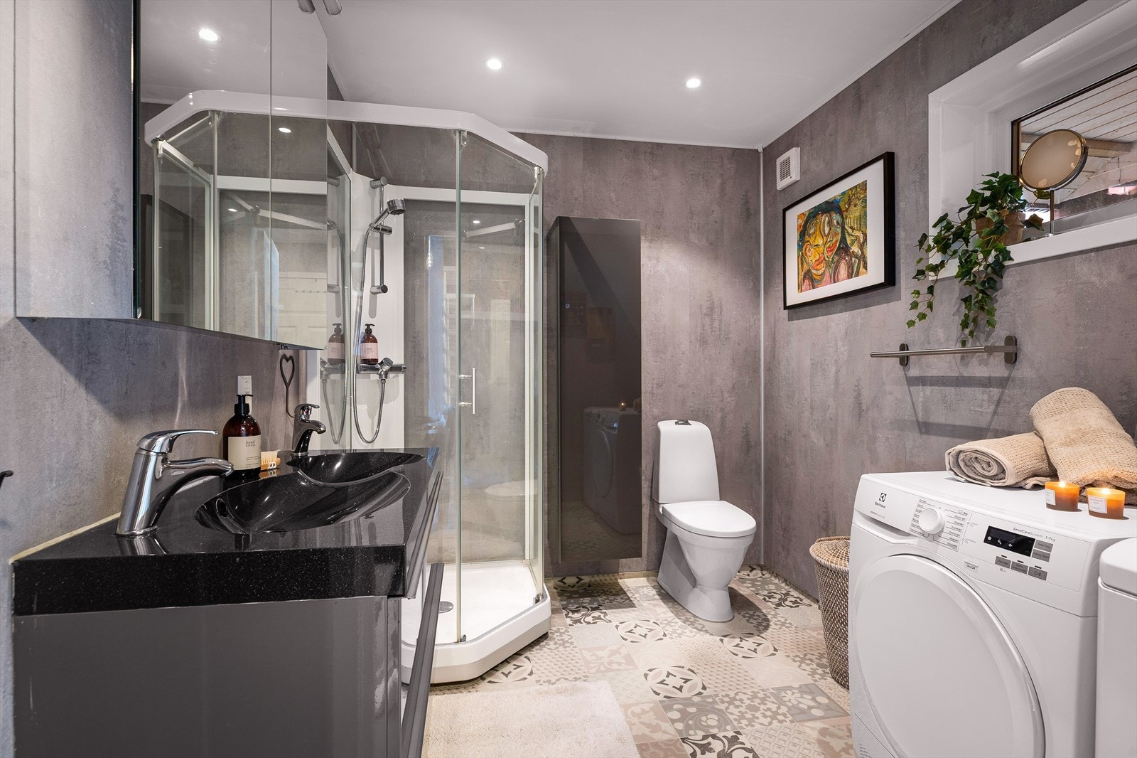 Badet er innredet med servant med møblement, toalett og dusjkabinett. Galleribilde