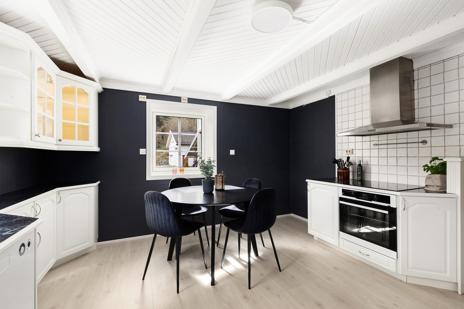 Kjøkken med mye innredning og god plass til spisebord Galleribilde