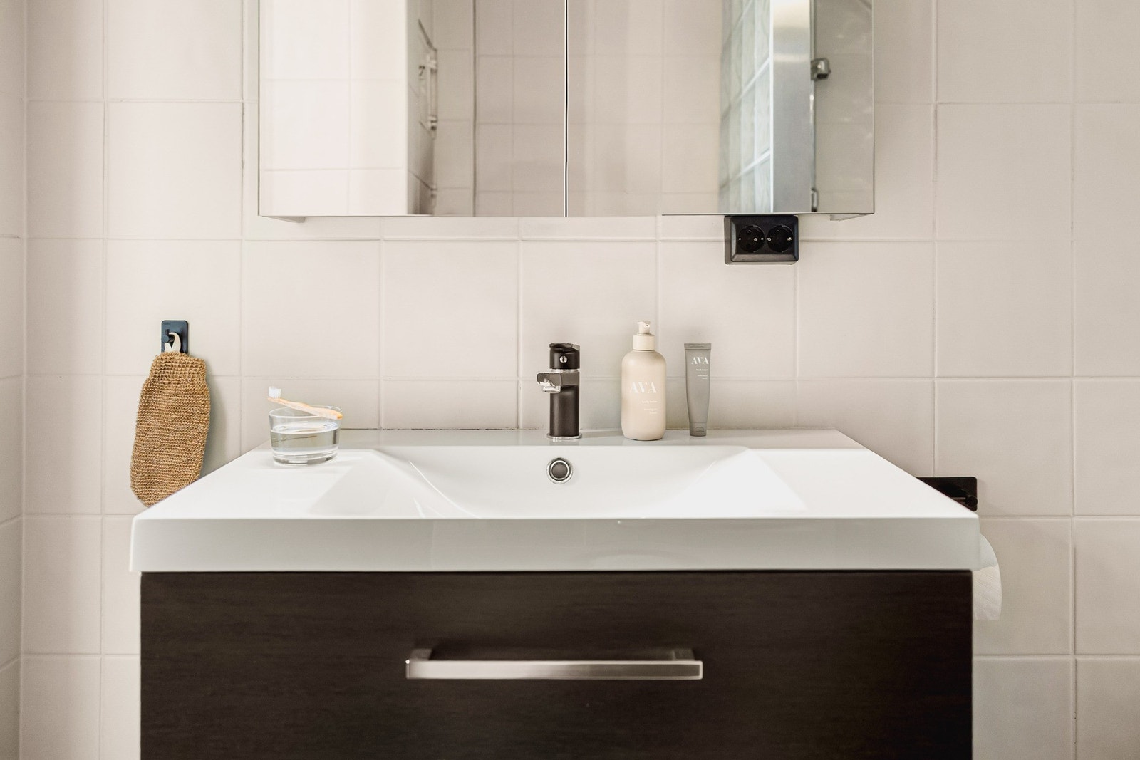 Badet er innredet med toalett, dusj med glassvegg, og et moderne baderomsmøblement med speil og belysning. Galleribilde