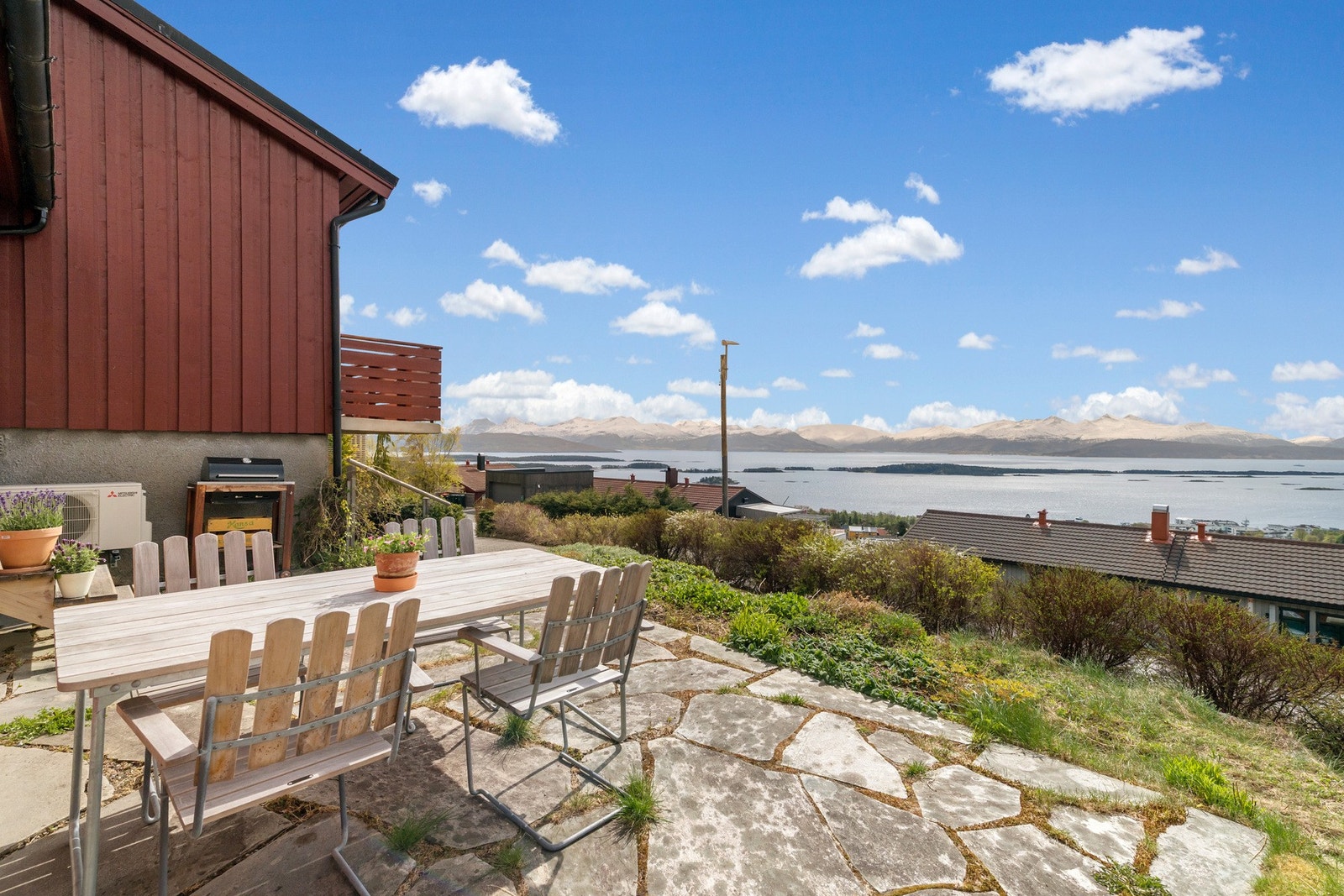 Eiendommen har flere, fine uteområder. Fra det skiferlagte uteområde sør for stuen er det orkesterplass til fjord og fjell. Galleribilde