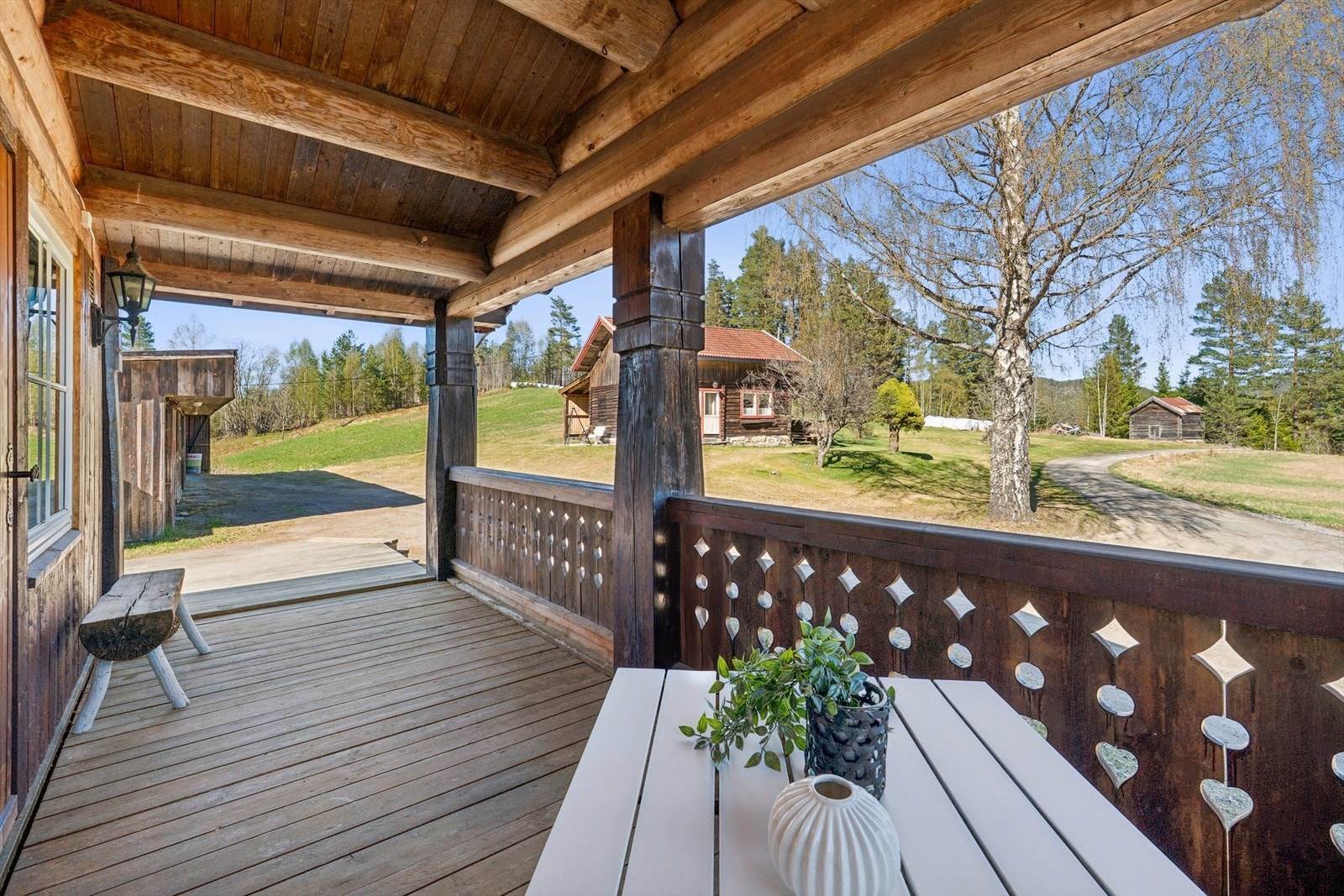 Fra den overbygde delen av terrassen ser man utover tunet mot sidebygningen og stabburet. Galleribilde