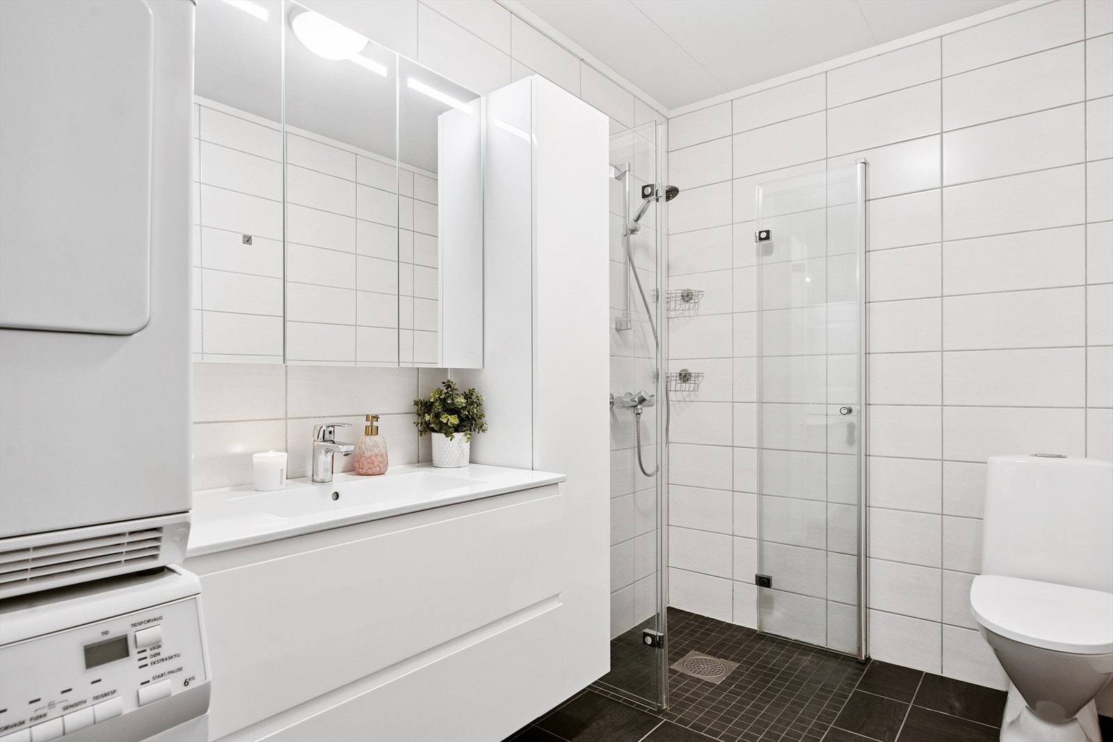 Baderomsinnredning med nedfelt servant og opplegg for vaskemaskin. Galleribilde