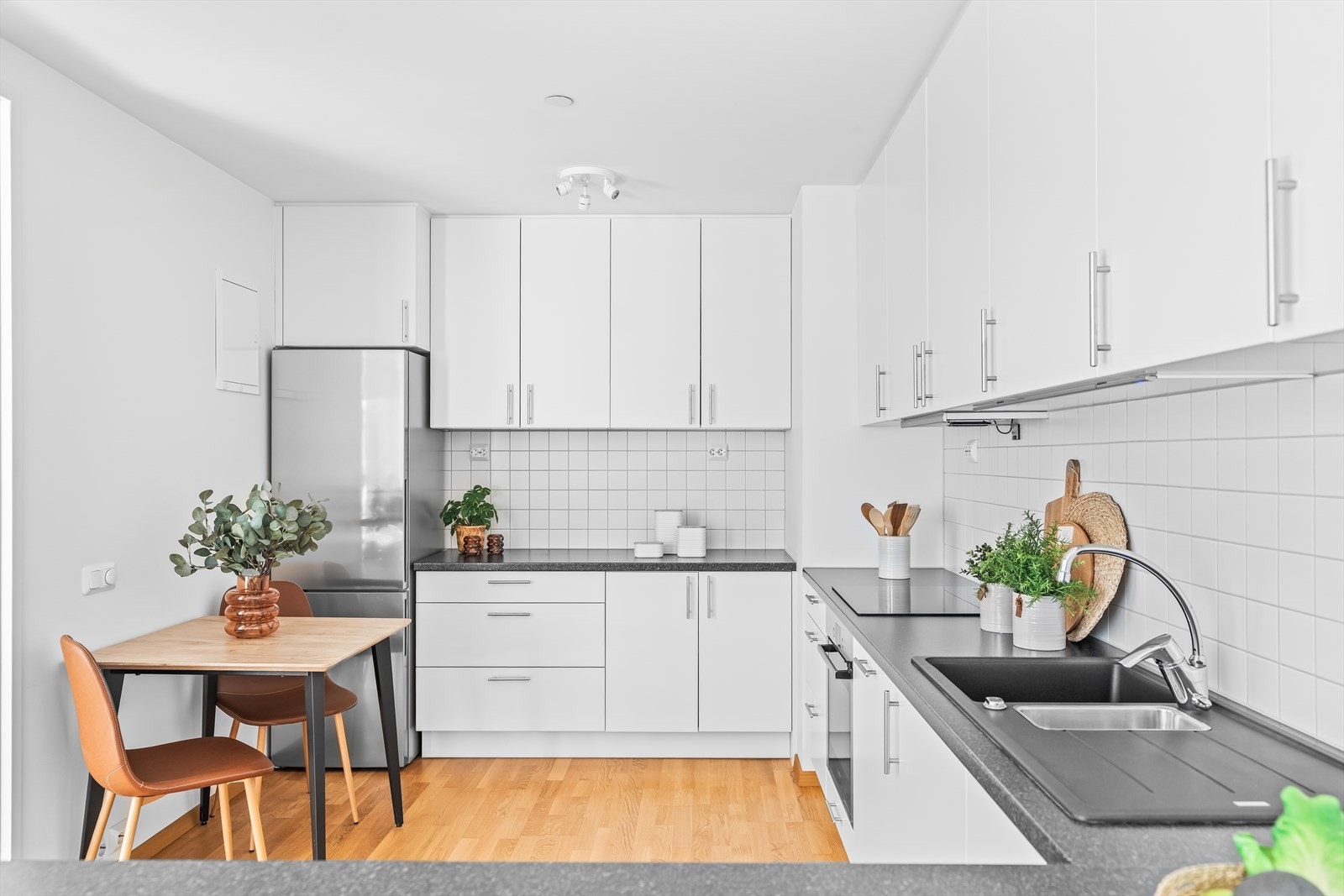 Kjøkkenet har en moderne innredning med hvite skapfronter, samt laminert benkeplate med nedfelt oppvaskkum og 1-greps blandebatteri. Galleribilde