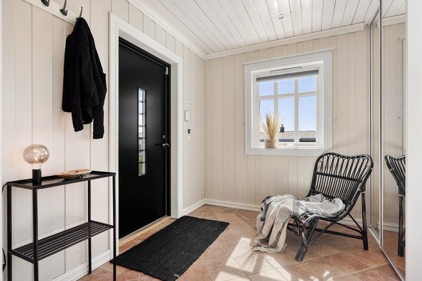 Entréen er lys og innbydende med praktisk flislagt gulv som tåler daglig bruk. Vegger og tak er kledd med panel. Galleribilde