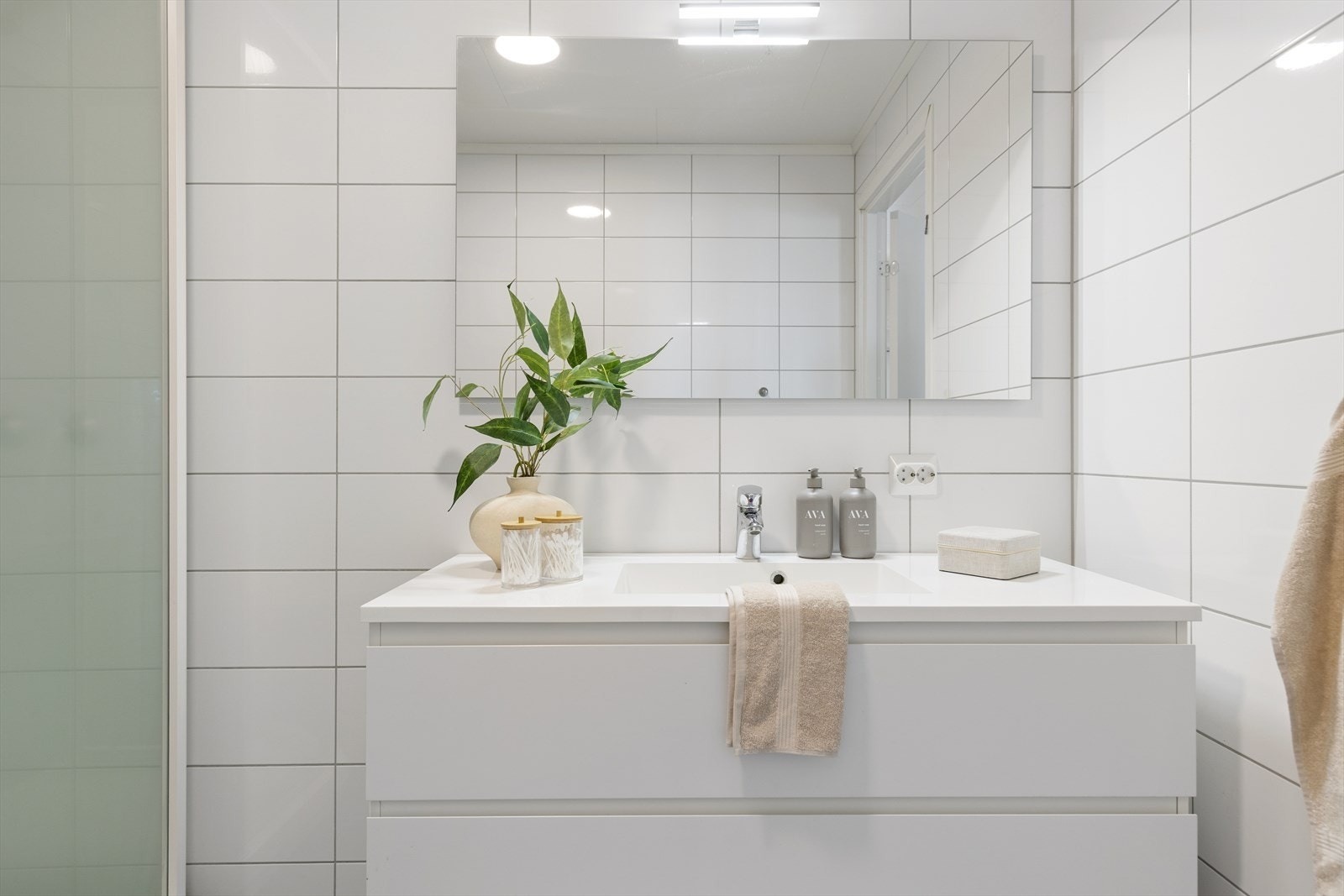 Rommet har en tidløs utførelse med gulvvarme og praktisk innredning bestående av servant med møbel, toalett og dusjkabinett. Galleribilde
