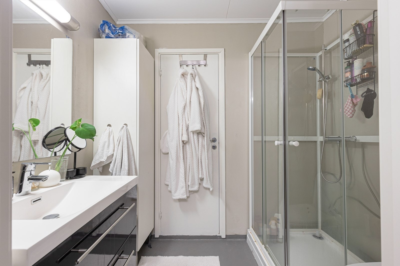 Badet er hovedsakelig fra byggeår og har varmekabel i gulv, innredning med vask, toalett og dusjkabinett. Galleribilde