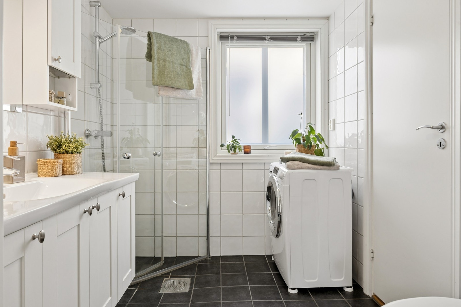 Flislagt bad med opplegg for vaskemaskin. Inngang til praktisk bod som egner seg godt som tørkerom. Galleribilde