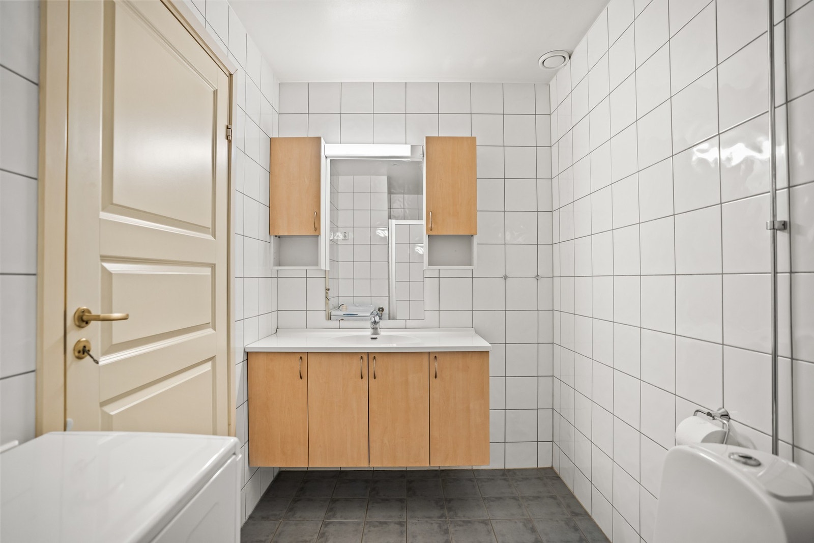 Flislagt bad med gulvvarme, dusjnisje med glassvegger og opplegg for vaskemaskin. Galleribilde