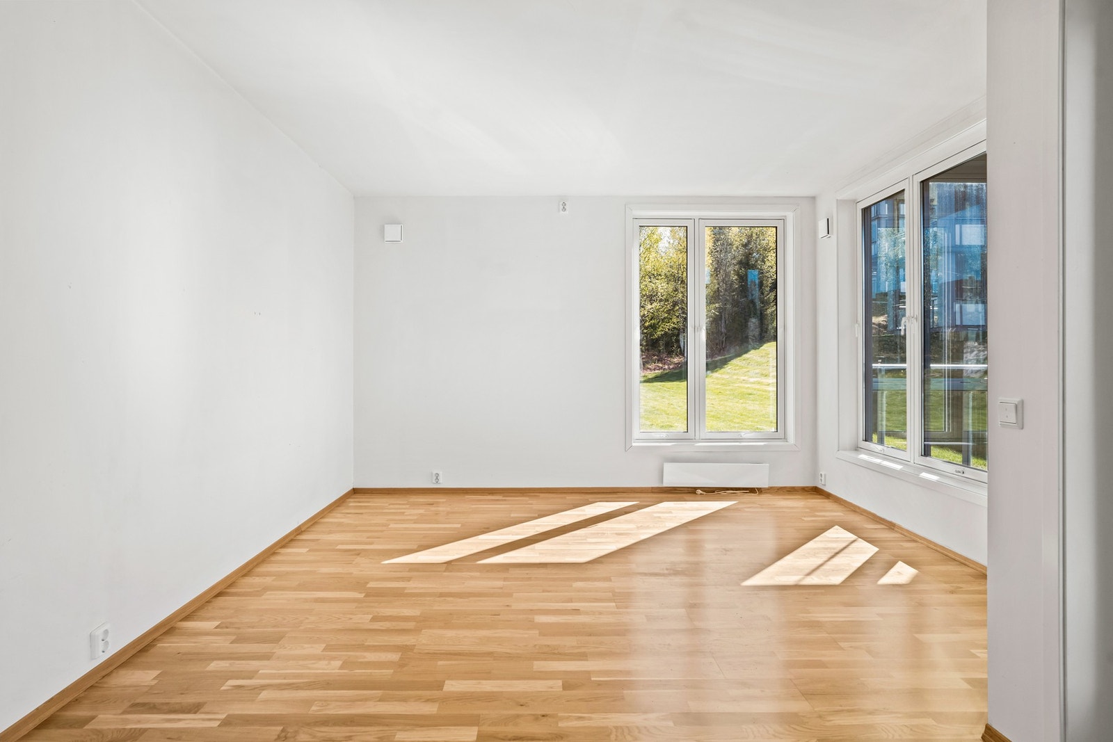Lys og romslig stue med store vindusflater og utgang til innglasset balkong. Galleribilde