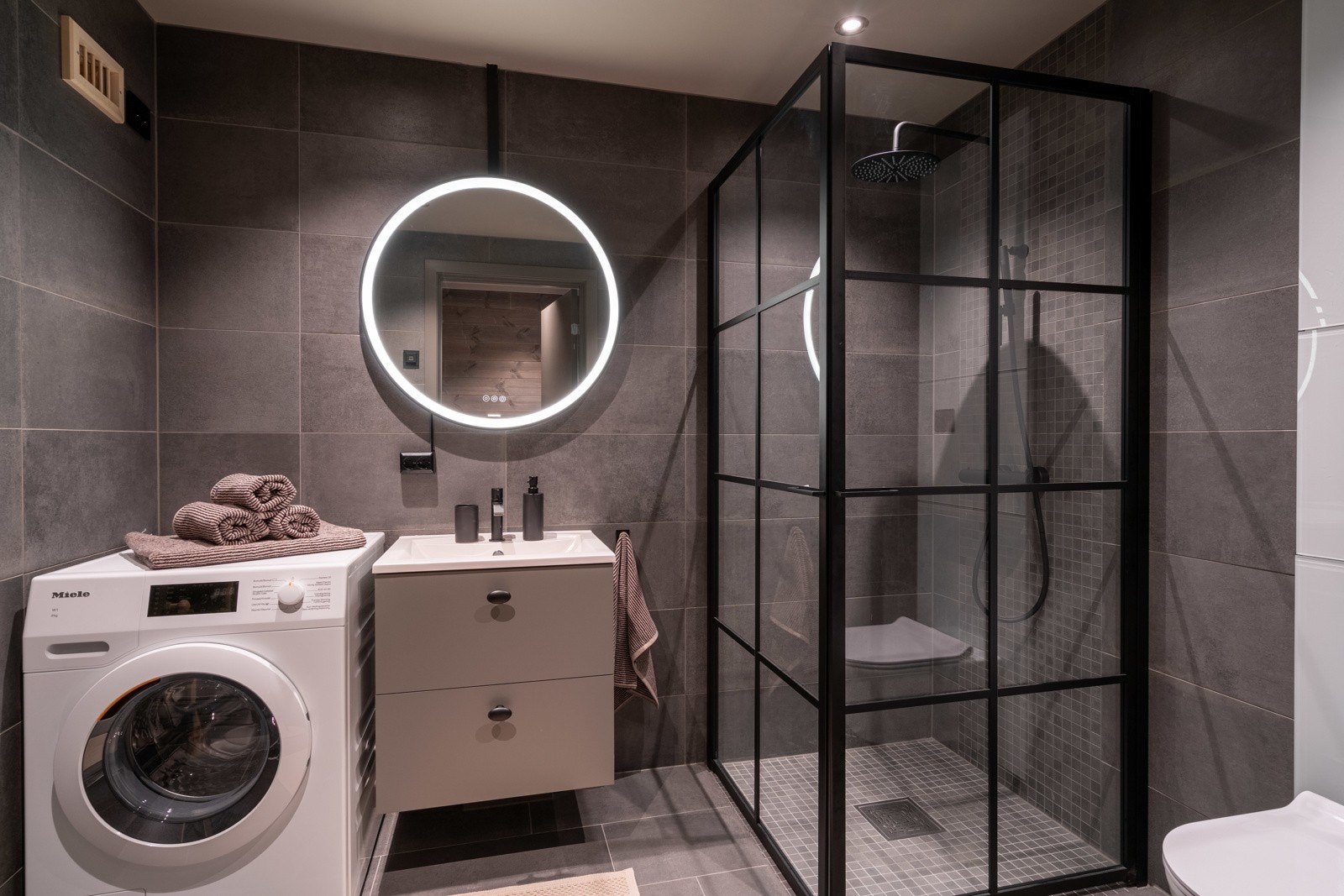 Badet har bl.a. opplegg for vaskemaskin og adkomst til badstuen. Galleribilde
