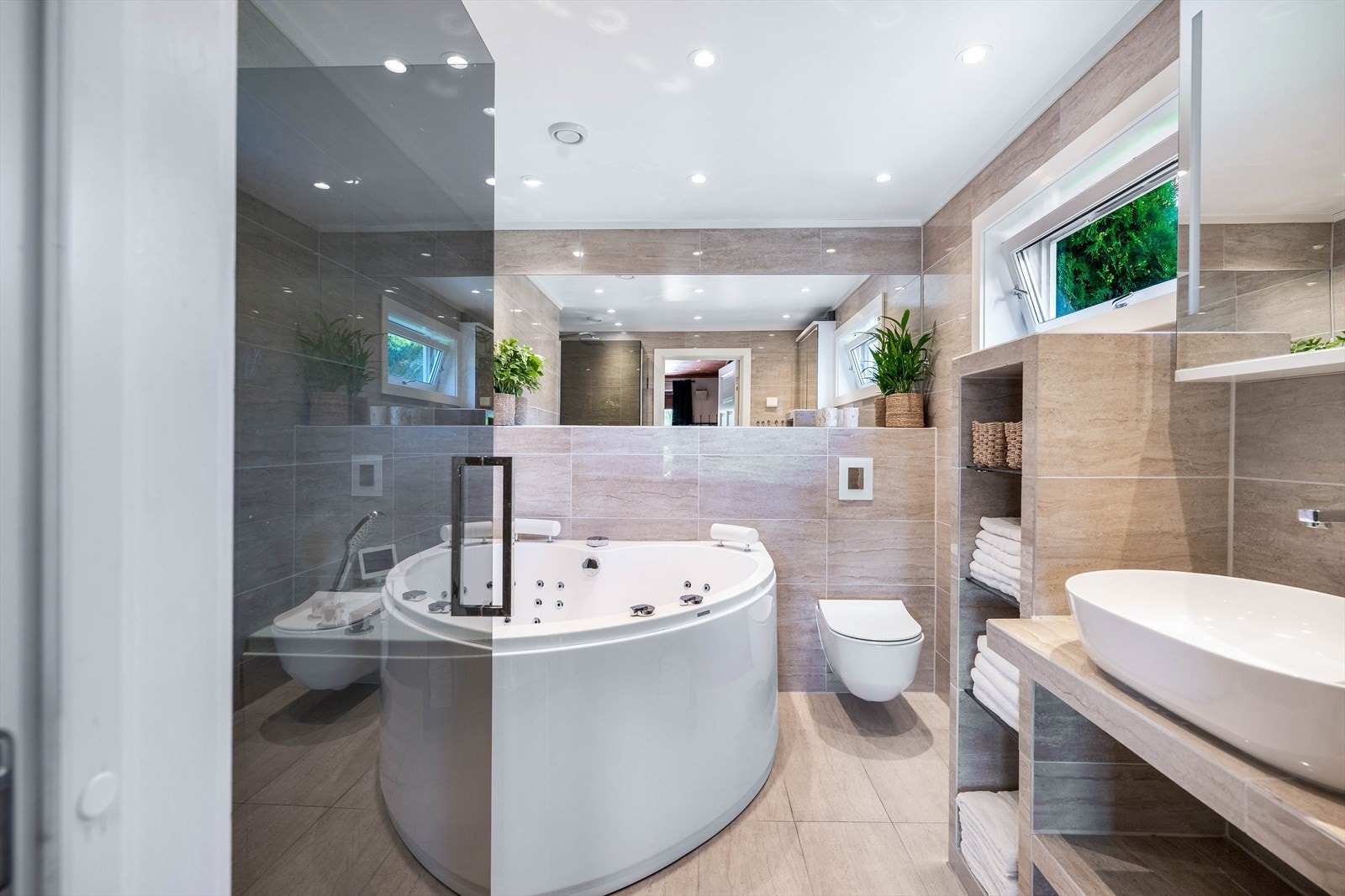Badet ble pusset opp i 2018 og er lekkert innredet plassbygde og flislagte hyller Galleribilde