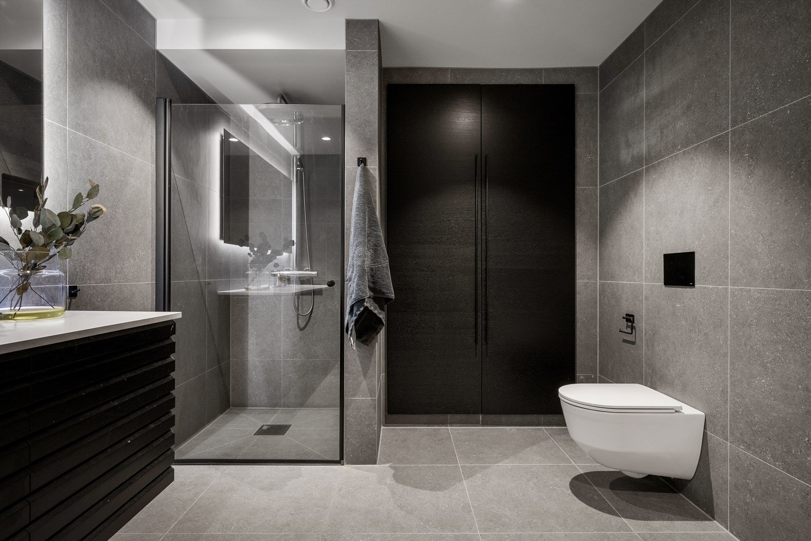 Badet er utstyrt med dusjnisje med glassdør, vegghengt toalett og en moderne servant. Galleribilde