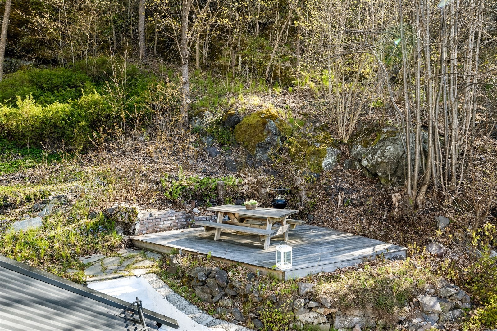 I hagen finner du en usjenert terrasseplatting på 15 m², lagt rett på marken. Galleribilde