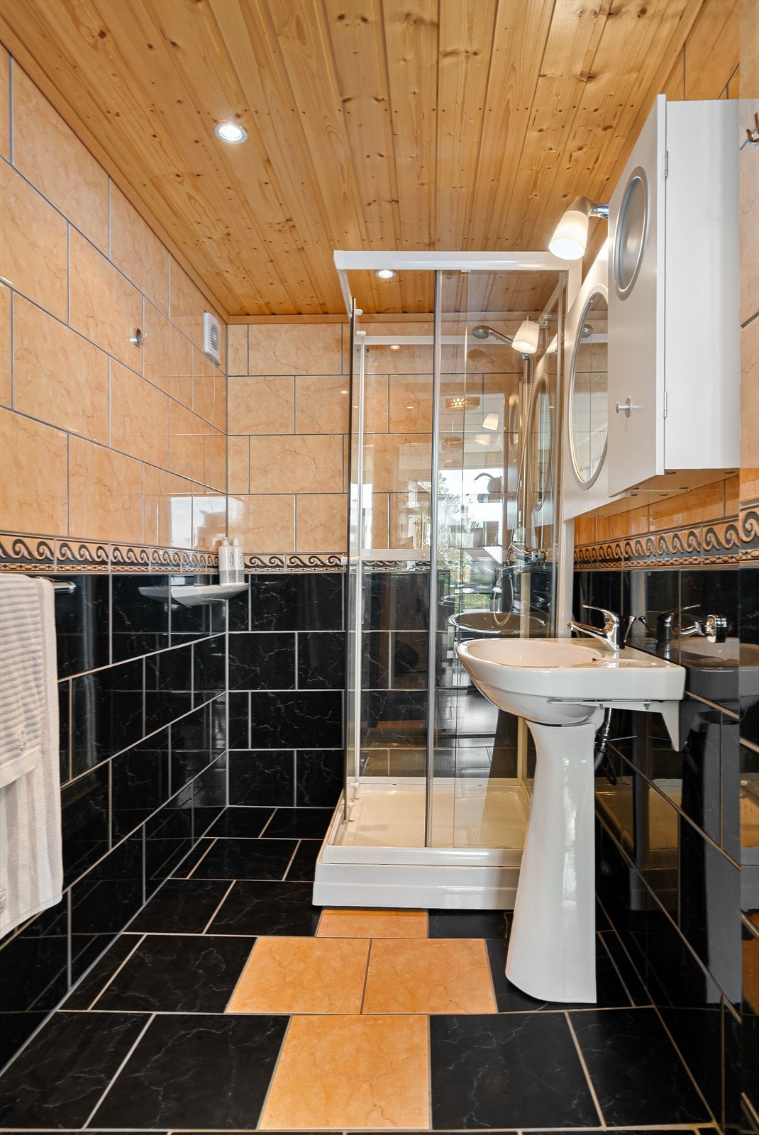 Badet er utstyrt med dusjkabinett og servant. Galleribilde
