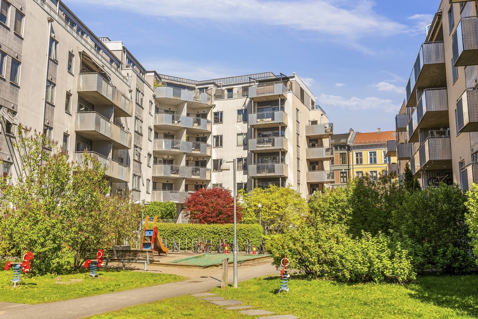 Stor, grønn og velstelt bakgård som gir et hyggelig utemiljø. Galleribilde