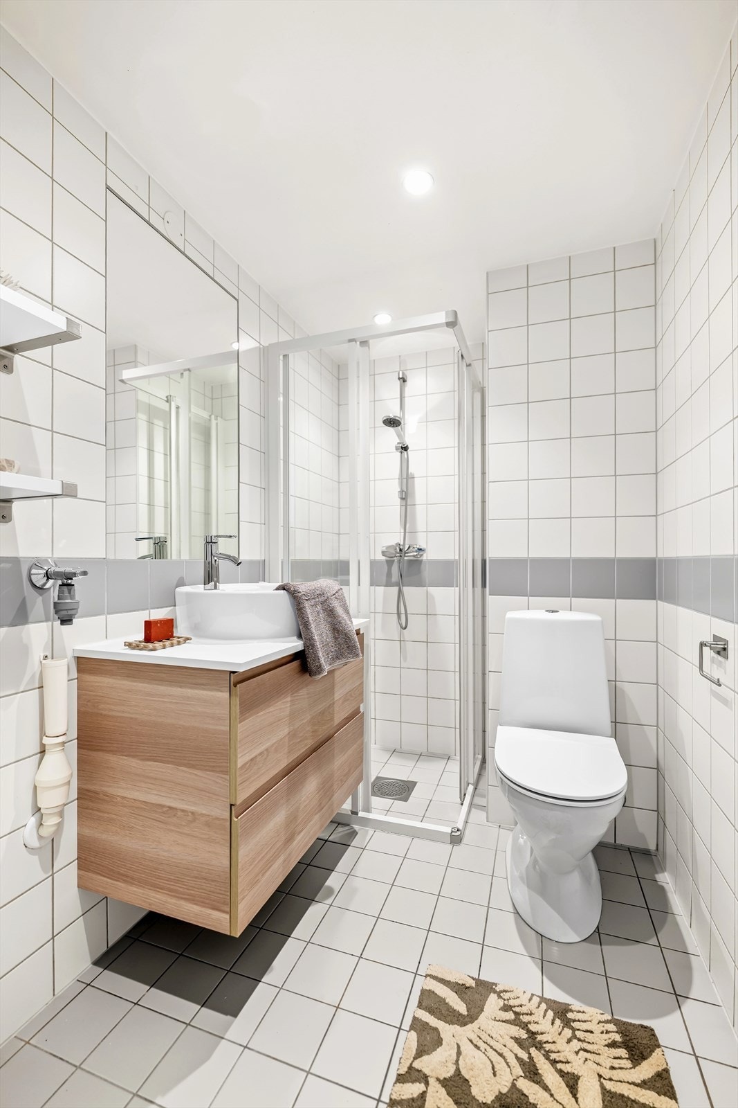 Flislagt bad fra 2005 med tidløst uttrykk, gulvvarme og opplegg for vaskemaskin. Galleribilde