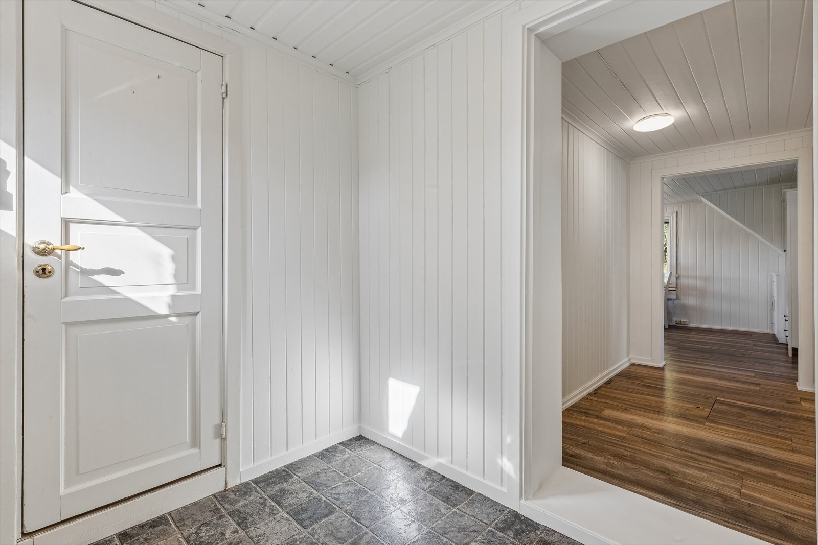 Entréen har slitesterke gulvfliser og leder videre inn i boligen. Rommet var en del av et tilbygg fra 1978. Galleribilde