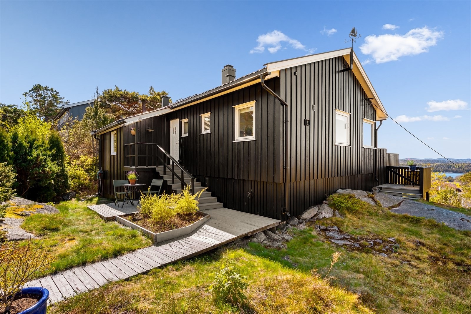 Hytta ligger fint til i det skrånende terrenget, omgitt av naturtomt. Galleribilde