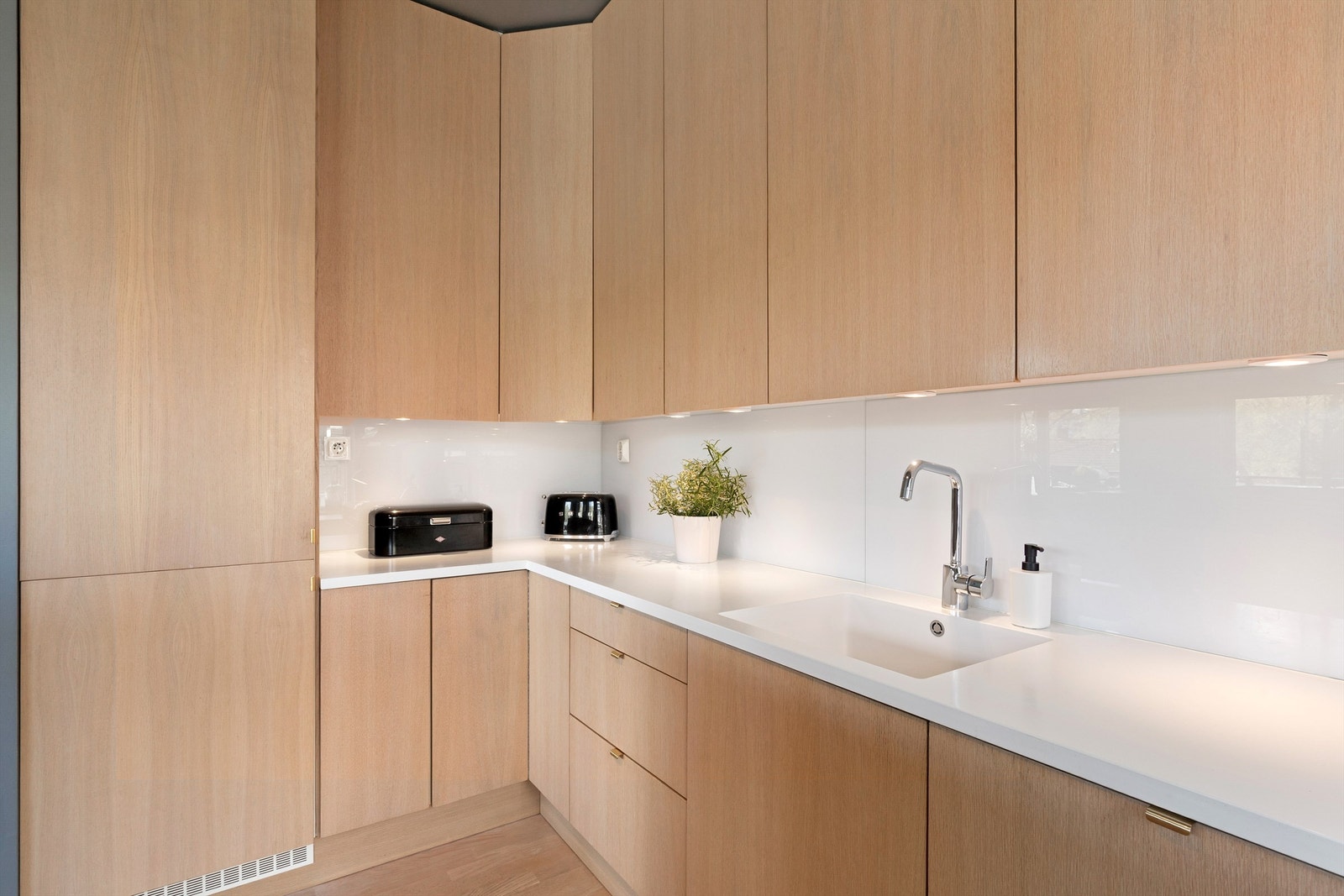 Corian benkeplate med glassplate mellom benk og overskap Galleribilde