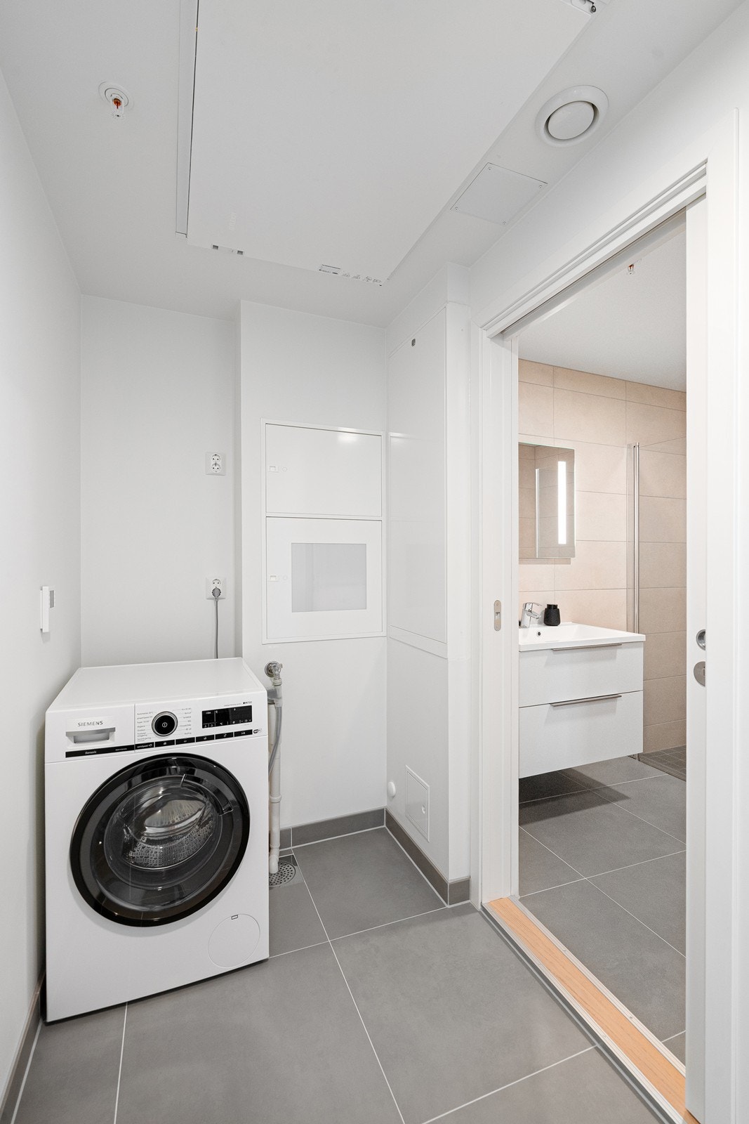 Vaskerommet med direkte adkomst til badet, praktisk og funksjonelt Galleribilde