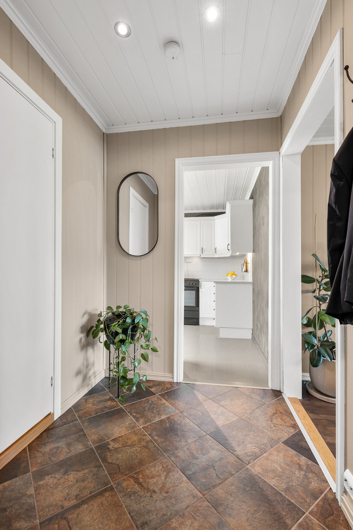 Entré med flislagt gulv, malte panelplater på vegger og panelbord i himling Galleribilde