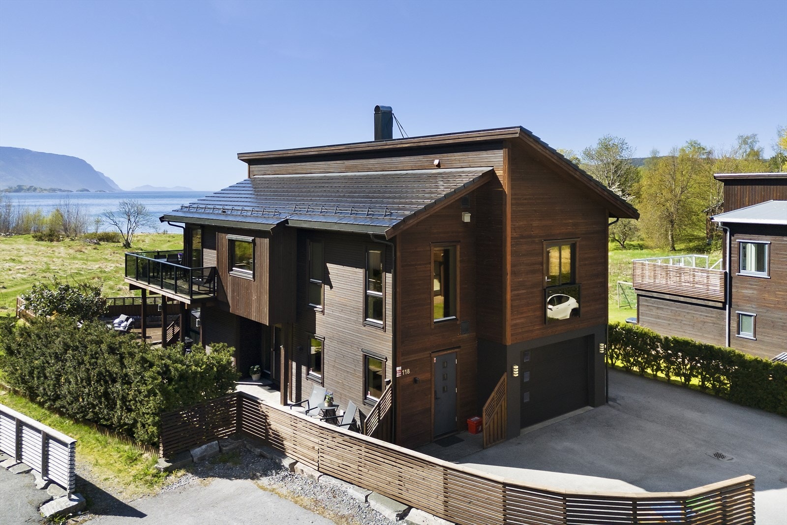 Tomten er lettstelt med asfalterte flater, en liten gressflekk og terrasse i fremkant. Galleribilde