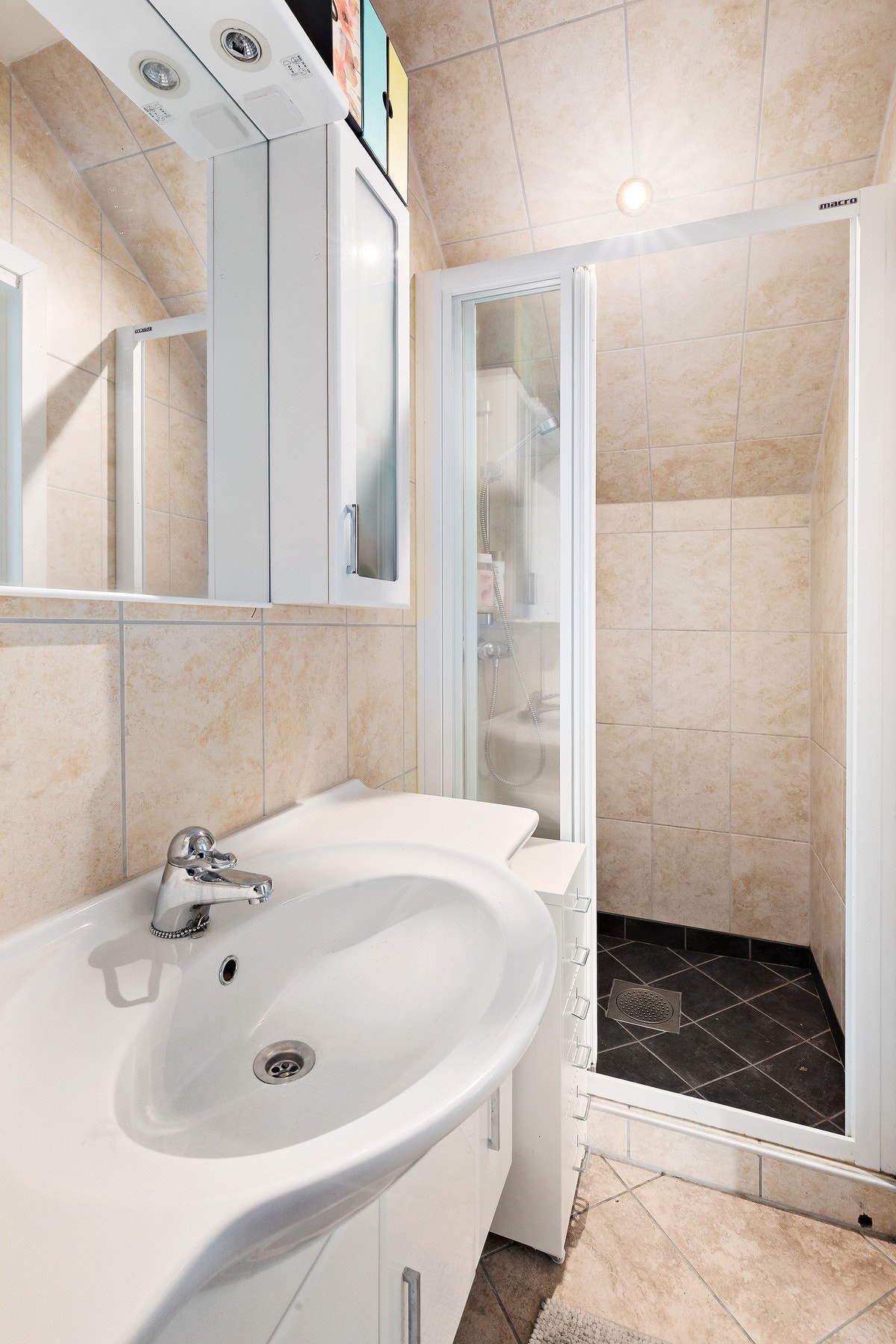 Badet er utstyrt med WC, servant, speil- og servantskap samt dusjnisje. Galleribilde