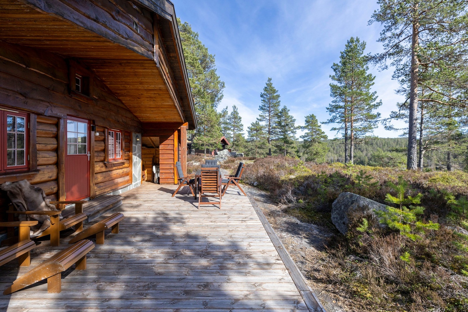 Terrassen strekker seg langs hytten og byr på naturskjønne omgivelser med utsyn mot flott fjellandskap og furuskog. Galleribilde