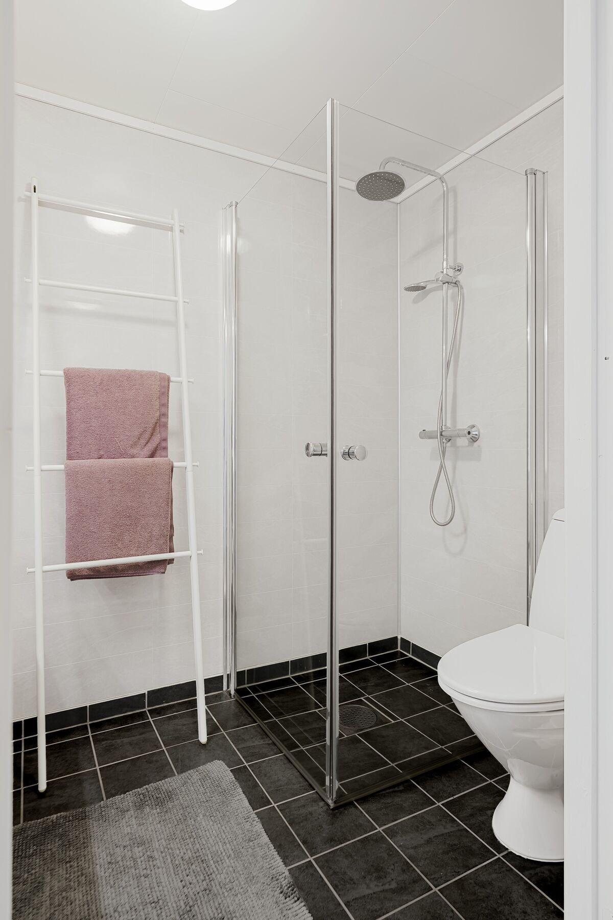 Badet inneholder servant i innredning, dusjplass og toalett Galleribilde
