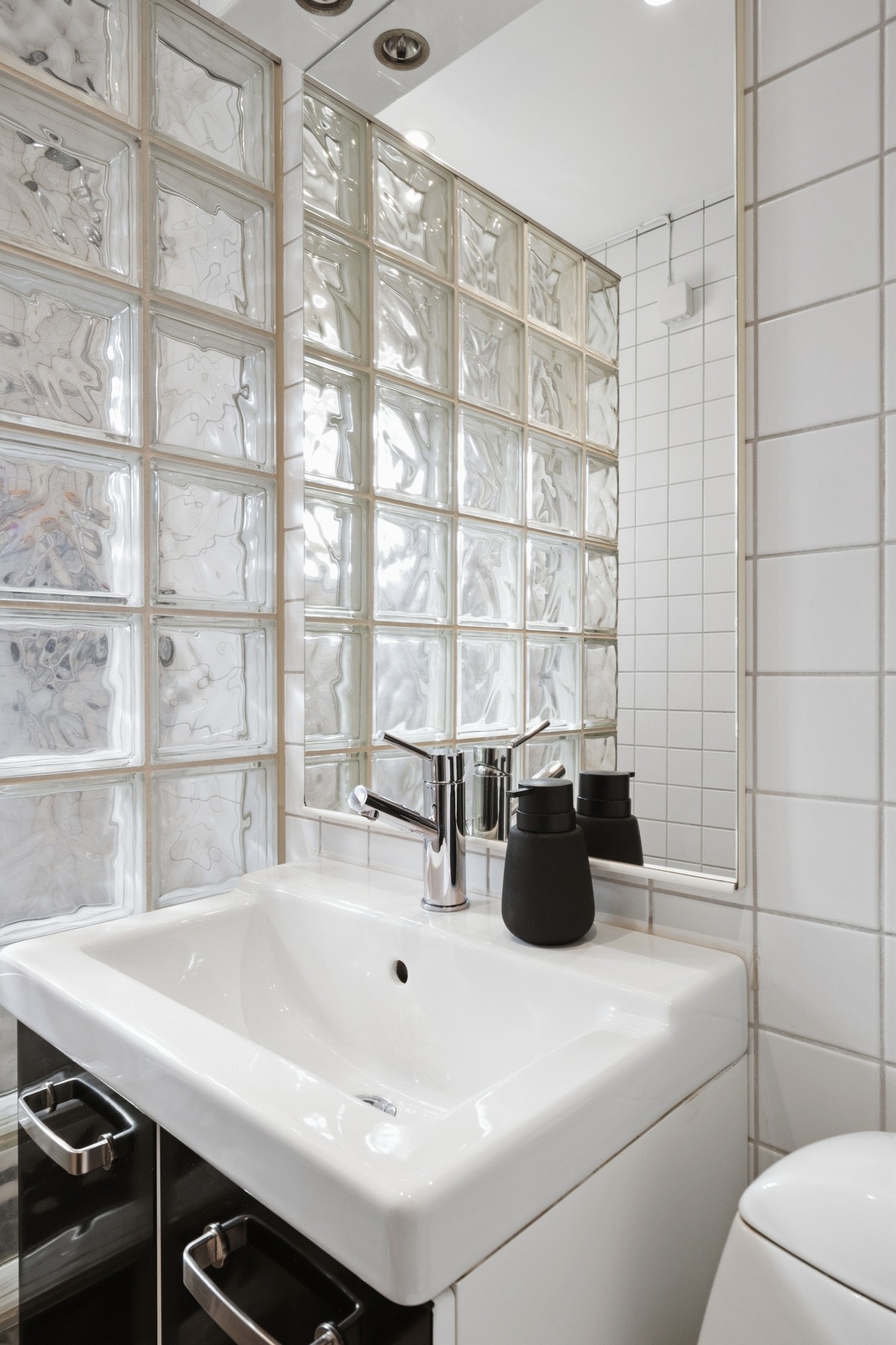 Varme er lagt i gulvet, og badet har toalett, downlights og dusjhjørne med vegg av glassbyggerstein Galleribilde