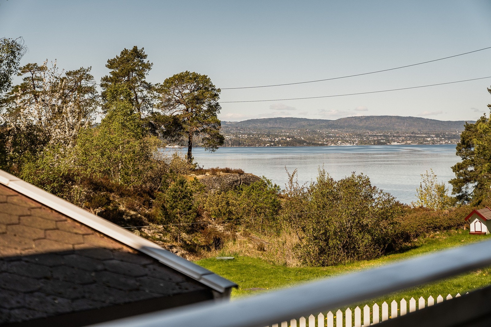 Fra terrassen har du flott utsyn mot både vannet og de frodige grøntområdene rundt boligen. Galleribilde