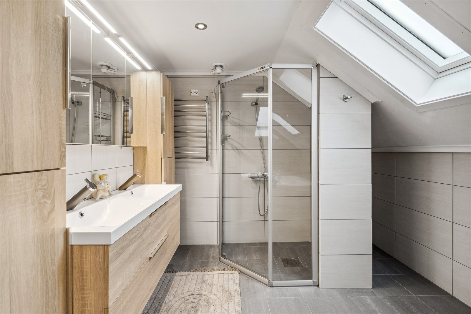 I rommet er det vaskeservant i innredning, gulvmontert wc, dusjnisje med glassdører og innebygget badekar. Galleribilde