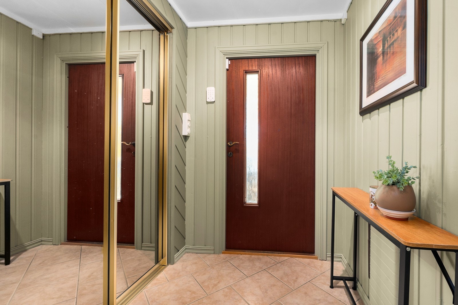 Lys og praktisk entré med flislagt gulv og god oppbevaringsplass i skyvedørsgarderobe. Galleribilde