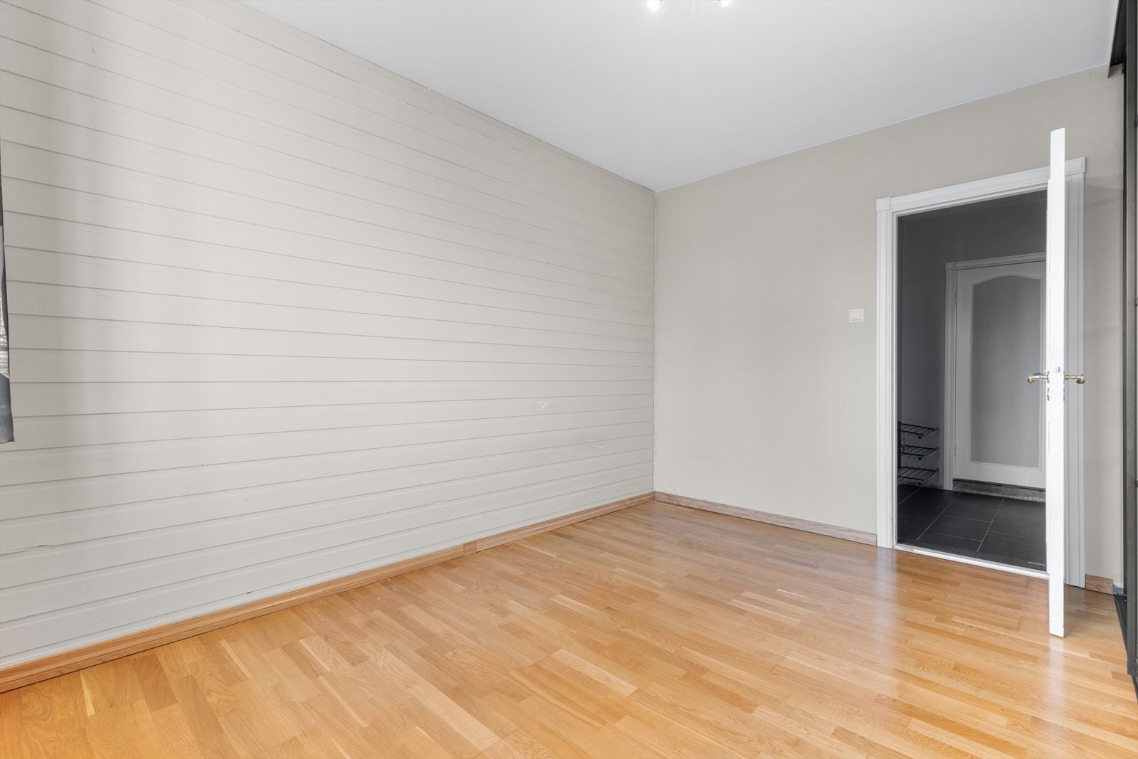 En av veggene på soverommet er kledd med panel, som gir rommet karakter. Galleribilde