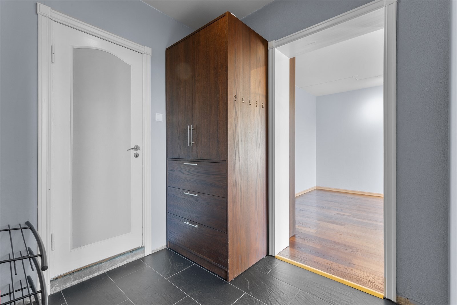 Entré med fliser på gulv. Leiligheten disponerer to boder for ekstra lagring, én i kjeller og én på loft. Galleribilde