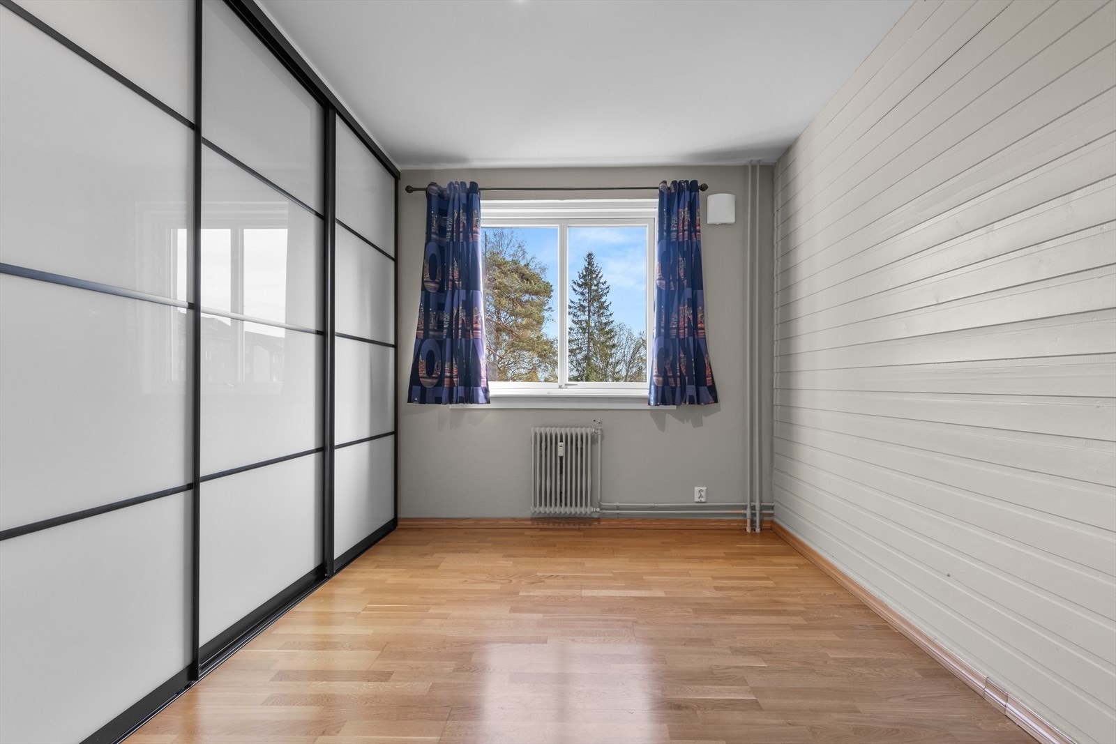 Soverommet har en hel vegg med skyvedørsgarderobe som gir rikelig med oppbevaringsplass. Galleribilde